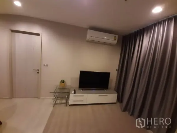 คอนโด ให้เช่าหรือขายในKhlong Toei, Bangkok - ชั้นวางทีวีและเครื่องปรับอากาศ ตรงข้ามผ้าม่านเต็มผนังในห้องนั่งเล่น