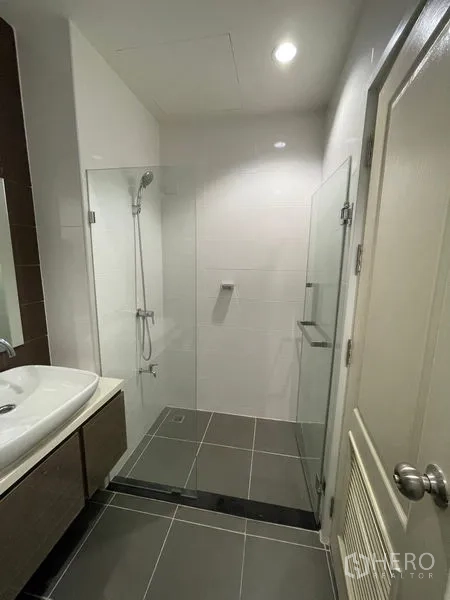 Townhouse for rent in Bang Kapi, Bangkok - Glass-enclosed shower with handheld showerhead in a contemporary bathroom.