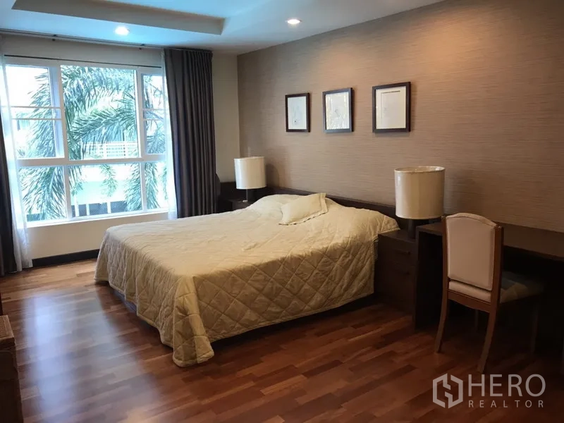 Condominium for rent in Watthana, Bangkok - Spacious master bedroom with wood floors, queen bed, desk and large window.