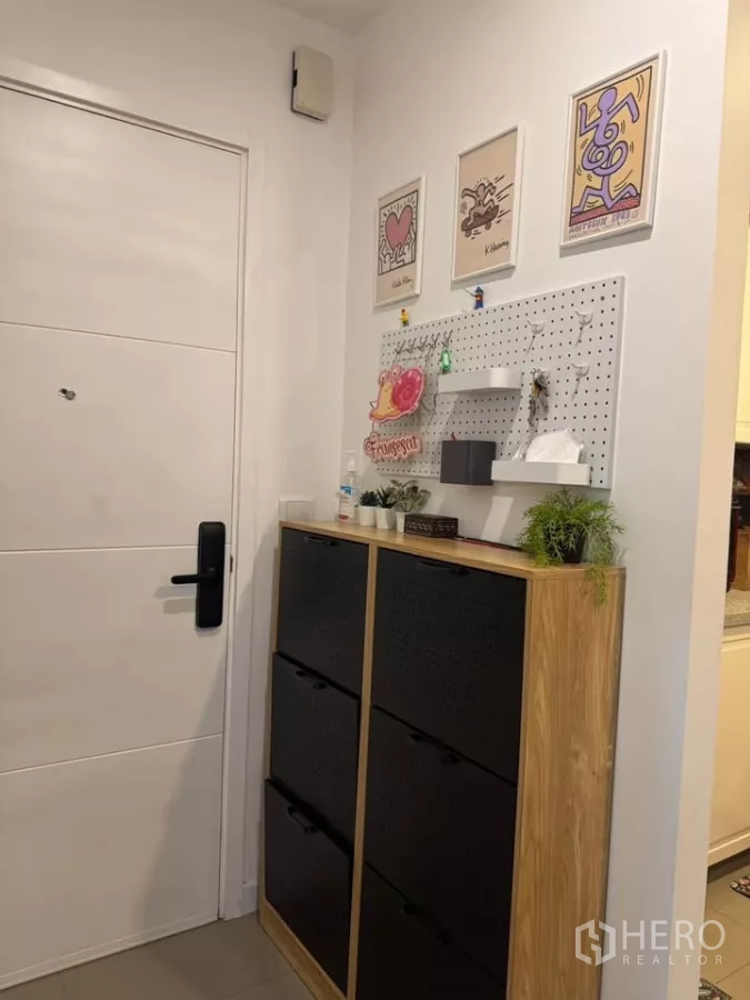 Condominium for rent in Watthana, Bangkok - Entry foyer with shoe cabinet, pegboard for keys and decorative frames.