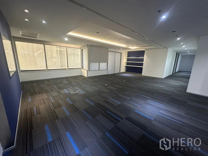 สำนักงาน ให้เช่าในKhlong Toei, Bangkok - โซนสำนักงานเปิดโล่ง ผนังสีน้ำเงิน ไฟฝ้าซ่อน และพรมแผ่น