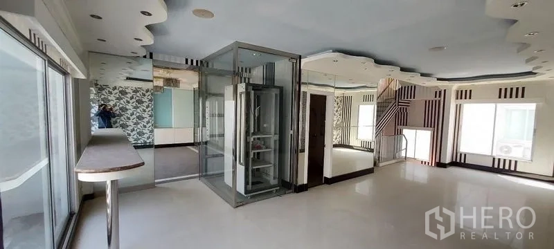 Home Office for sale in Wang Thonglang, Bangkok - Large office floor featuring a glass lift, mirrors and wide windows.