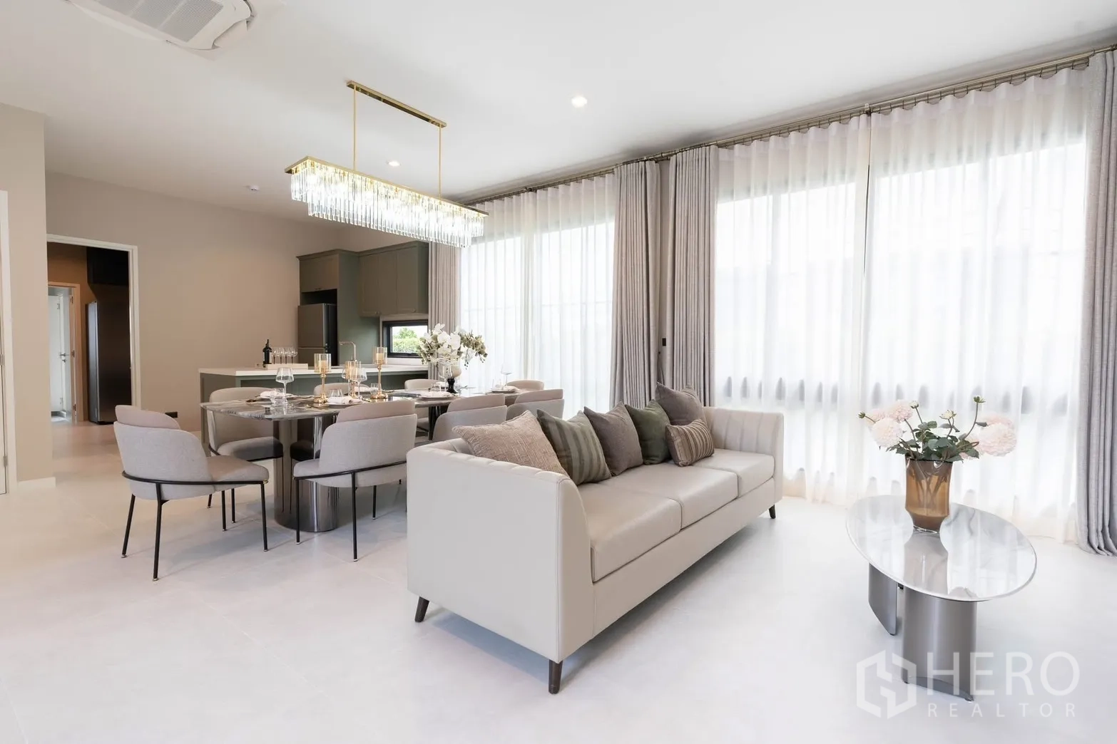Detached House for rent in Bang Phli, Samut Prakan - Open-plan living–dining space adjoining kitchen, with sofa and glass table.