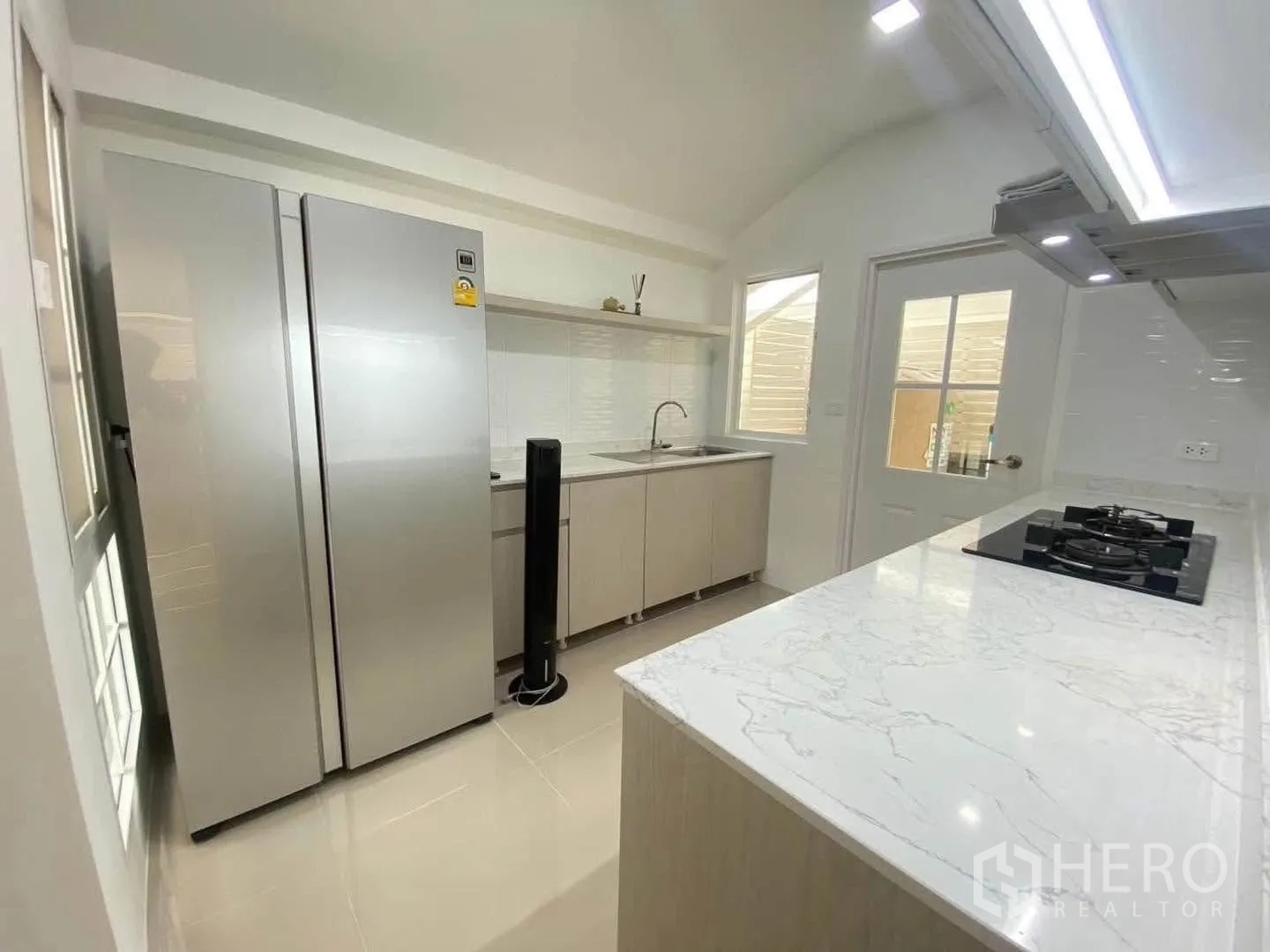 Detached House for rent in Mueang Samut Prakan, Samut Prakan - Kitchen view with side-by-side fridge, sink, and ample counter space.