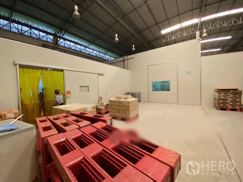 货栈 出租在Bueng Kum, Bangkok - 仓库角落设黄色软帘、隔断房间与堆放的塑料筐。