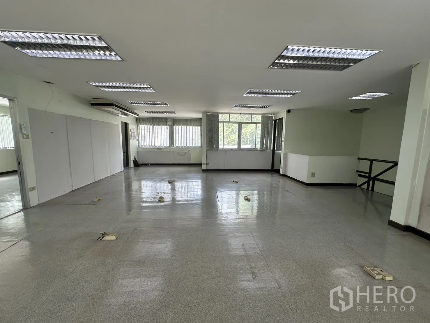 零售空间 出租在Watthana, Bangkok - 开放办公室，灰色地面、吊顶灯与转角窗。