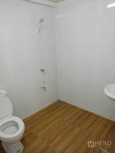 อาคารพาณิชย์ ให้เช่าในWatthana, Bangkok - ห้องน้ำเรียบง่ายพร้อมโถสุขภัณฑ์ ฝักบัว อ่างล้างมือ ผนังกระเบื้องขาว และพื้นลายไม้