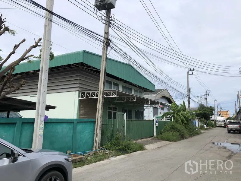 工厂 出租或出售在Samut Prakan - 沿通道的工厂外观转角视角，可见道路与架空电线。
