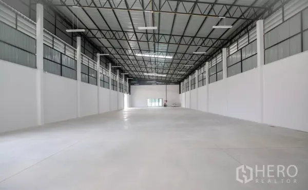 Factory for rent or sale in Bang Len, Nakhon Pathom - Spacious warehouse interior with high steel truss roof and polished concrete floor.