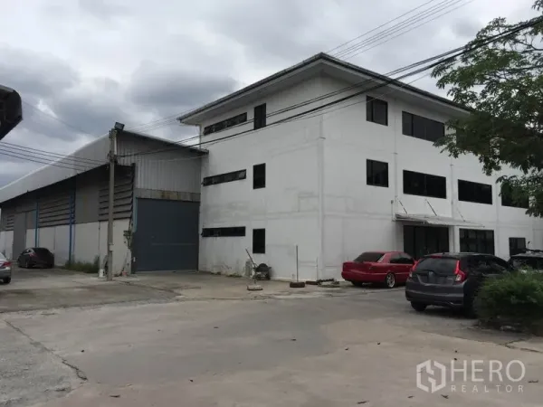 货栈 出租在Saphan Sung, Bangkok - 外观图：仓库连三层办公楼，设卷闸装卸门与地面停车位。