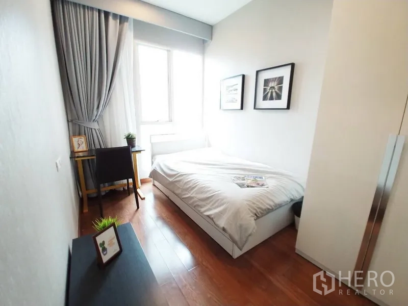 คอนโด ให้เช่าในPathum Wan, Bangkok - ห้องนอนเล็กอบอุ่น มีหน้าต่าง โต๊ะทำงาน ผ้าม่านสีเทา และกรอบรูป