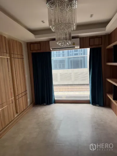 Shophouse for rent - Furnished room with a crystal chandelier, large front window, wood built-ins, and air conditioning.