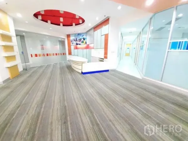 办公空间 出租在Bang Na, Bangkok - 大厅广角视图，弧形前台、玻璃隔断与通往办公间的走廊。