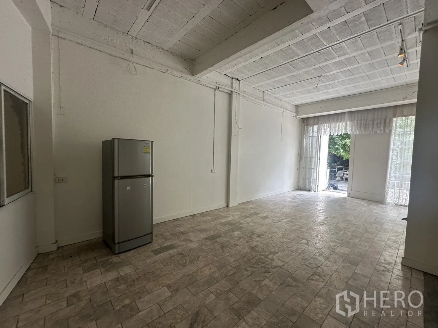Home Office for rent in Watthana, Bangkok - Open workspace with high ceiling, refrigerator, and light from front doors.