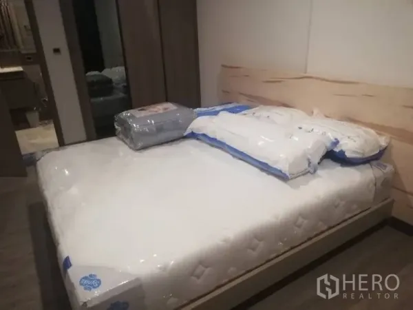 คอนโด ให้เช่าในWatthana, Bangkok - ห้องนอนพร้อมที่นอนใหม่ หัวเตียงไม้โทนอ่อน และตู้เสื้อผ้าบิวท์อิน มีทางเชื่อมไปยังห้องน้ำ