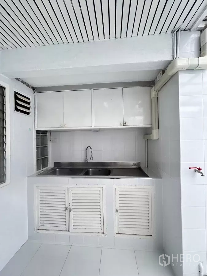 Detached House for rent in Suan Luang, Bangkok - Utility area with double stainless sink and white cabinets.