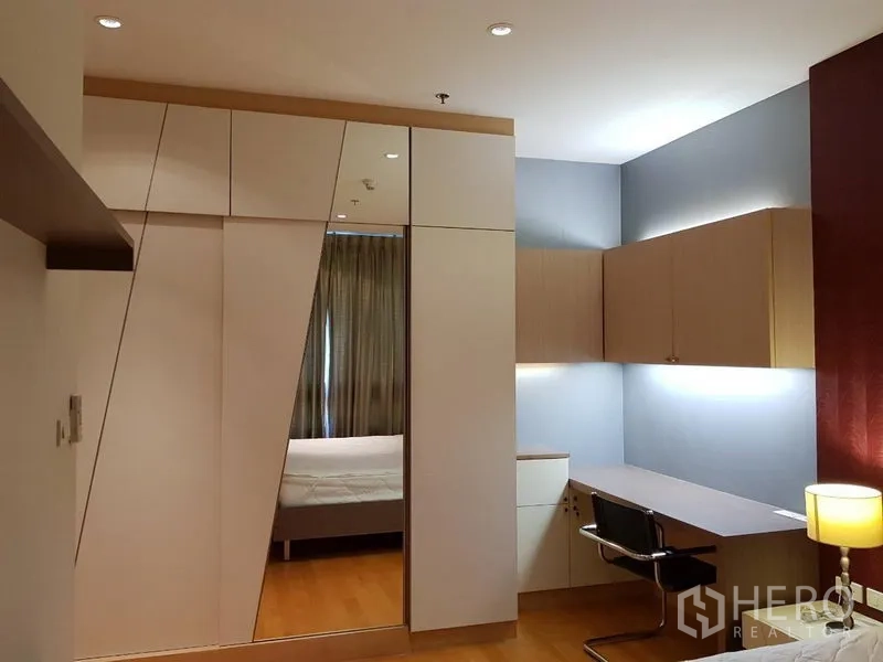 คอนโด ให้เช่าในRatchathewi, Bangkok - มุมห้องนอนพร้อมตู้เสื้อผ้าบิวท์อินลายเรขาคณิตบานกระจก และโต๊ะทำงานไฟใต้ตู้