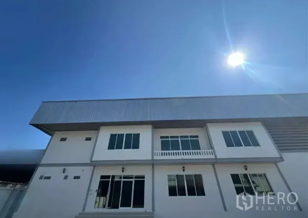 货栈 出租在Prawet, Bangkok - 现代两层仓库外立面，金属屋顶，蓝天晴日。