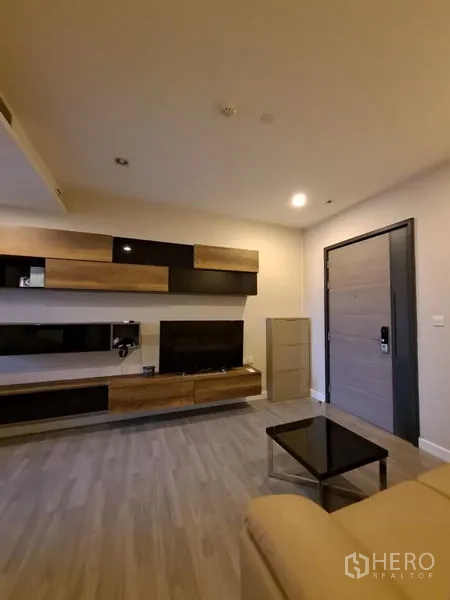 公寓 出租在Bang Rak, Bangkok - 现代客厅，木质与黑色一体化电视墙，浅木地板与入户门。