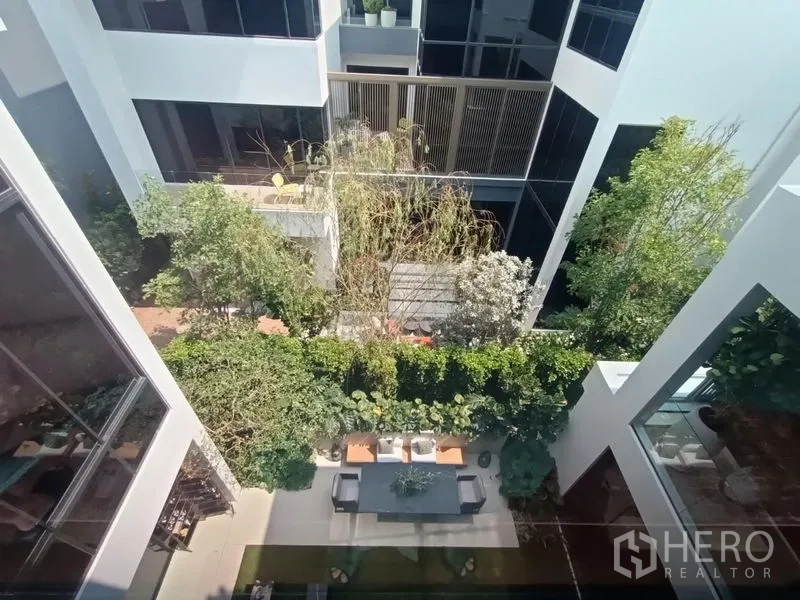 บ้าน ขาย - ด้านหน้าบ้านเดี่ยวสไตล์ร่วมสมัย มีที่จอดรถในร่มและสวนหน้าบ้าน