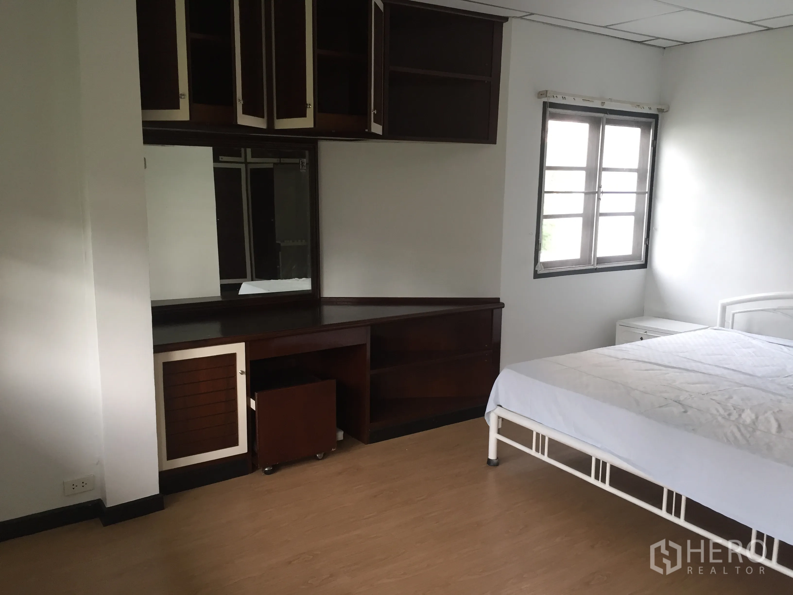 Townhouse for rent in Khlong Toei, Bangkok - Bedroom corner with built-in dressing table, large mirror, and overhead storage.