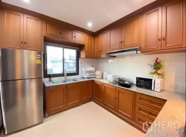 คอนโด ให้เช่าในKhlong Toei, Bangkok - ห้องครัวรูปตัว U ตู้ไม้บิวท์อิน หน้าต่าง ตู้เย็นสแตนเลส และเครื่องใช้ไฟฟ้า