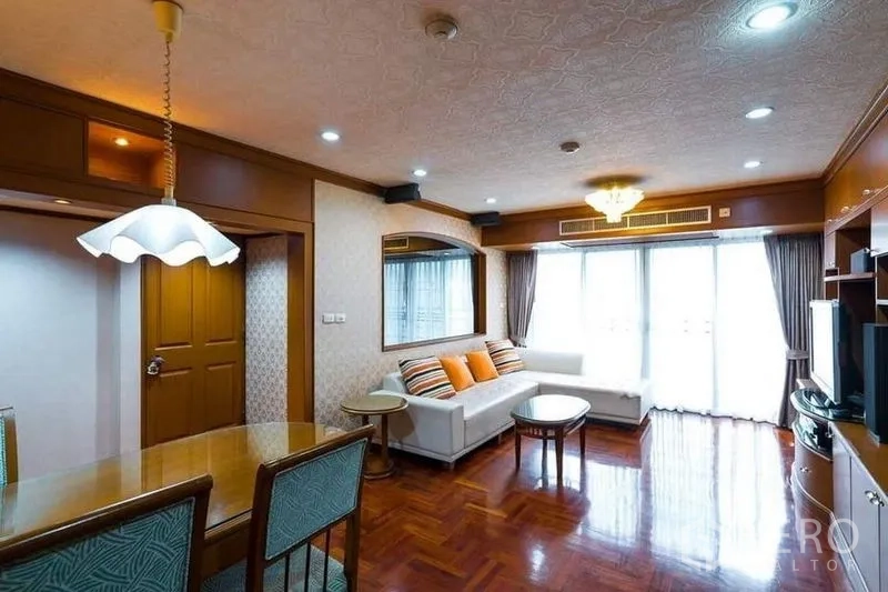 公寓 出租或出售在Bang Phlat, Bangkok - 客厅配L型沙发、木地板、筒灯，并有推拉门通阳台。