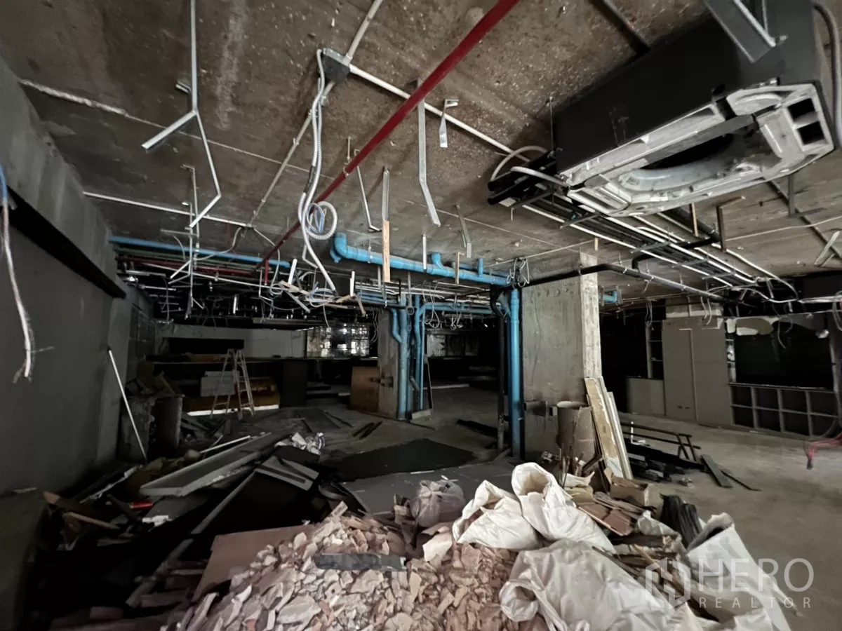 พื้นที่ขายปลีก ให้เช่าในKhlong Toei, Bangkok - เศษวัสดุก่อสร้างและท่อสายไฟห้อยใต้เพดานคอนกรีตเปลือย