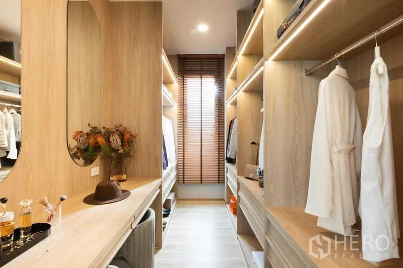 บ้าน ให้เช่าหรือขายในLat Krabang, Bangkok - ห้องแต่งตัวแบบวอล์กอิน ตู้ไม้สีอ่อนพร้อมไฟ และกระจกเงา