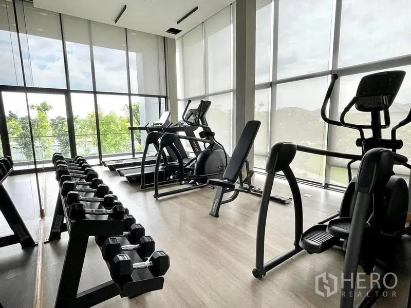 Detached House for rent in Bang Phli, Samut Prakan - Fitness center with free weights and cardio machines facing large windows.