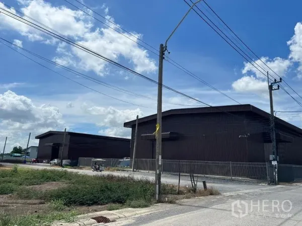 货栈 出租在Min Buri, Bangkok - 工业区内仓库与街道的广角视图。