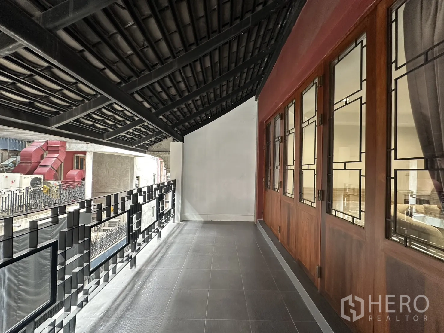 Apartment for rent in Pathum Wan, Bangkok - Long covered balcony with decorative metal railing and wood-framed windows.