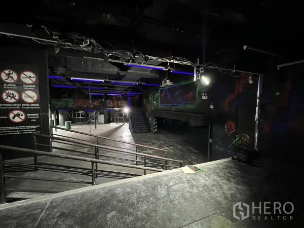 零售空间 出租在Khlong Toei, Bangkok - 开放式空间，带坡道、安全标识与夹层，黑色天花顶。