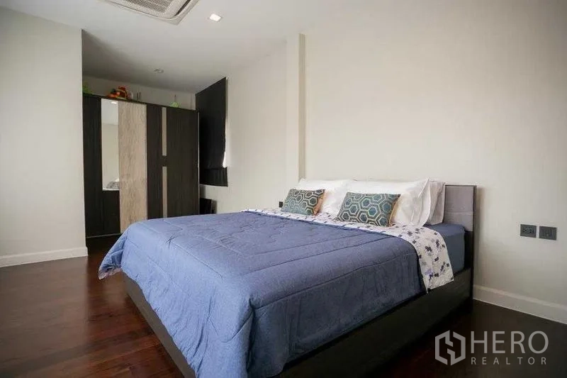 Detached House for rent in Bangkok - Third bedroom with queen bed, minimalist decor and freestanding wardrobe.
