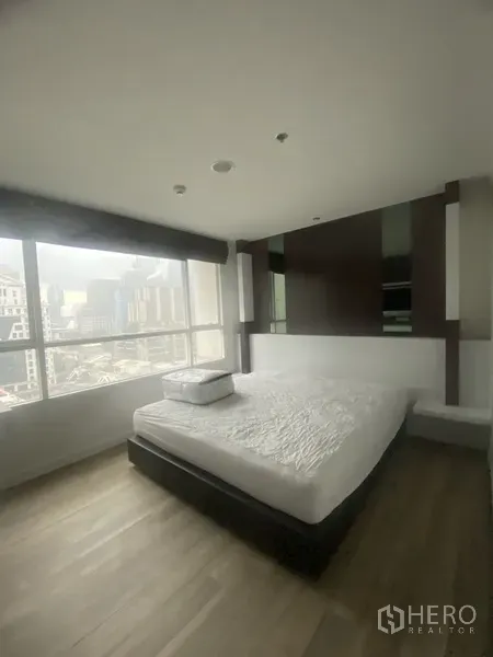 Condominium for rent in Pathum Wan, Bangkok - Master bedroom with king bed, floor-to-ceiling windows and urban views in a Bangkok condominium.
