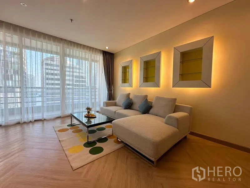 公寓 出租在Bang Rak, Bangkok - 客厅配纱帘与转角沙发，墙面装饰壁龛打光。