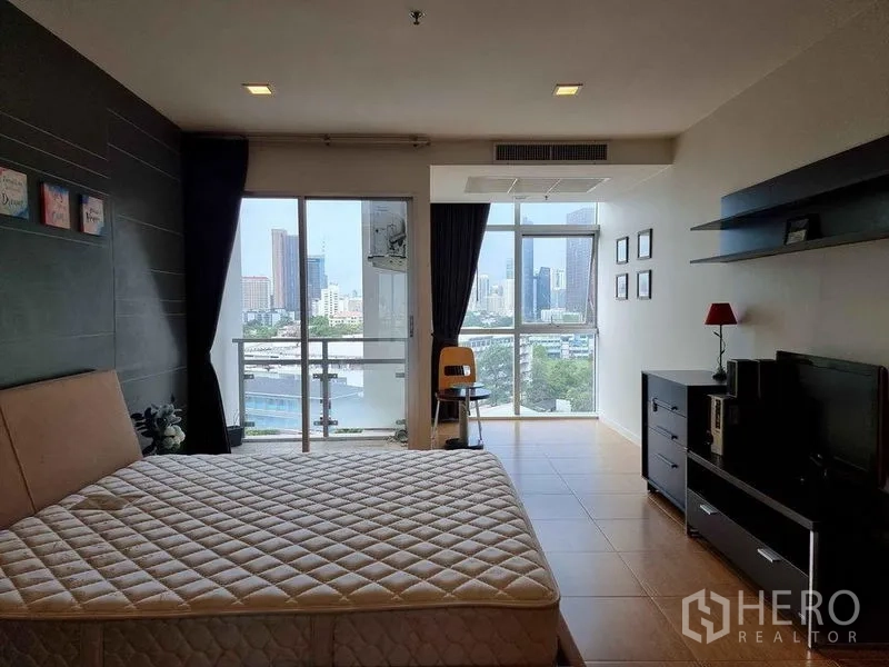Condominium for rent in Khlong Luang, Pathum Thani - Spacious bedroom with large bed, floor‑to‑ceiling windows and balcony city views.