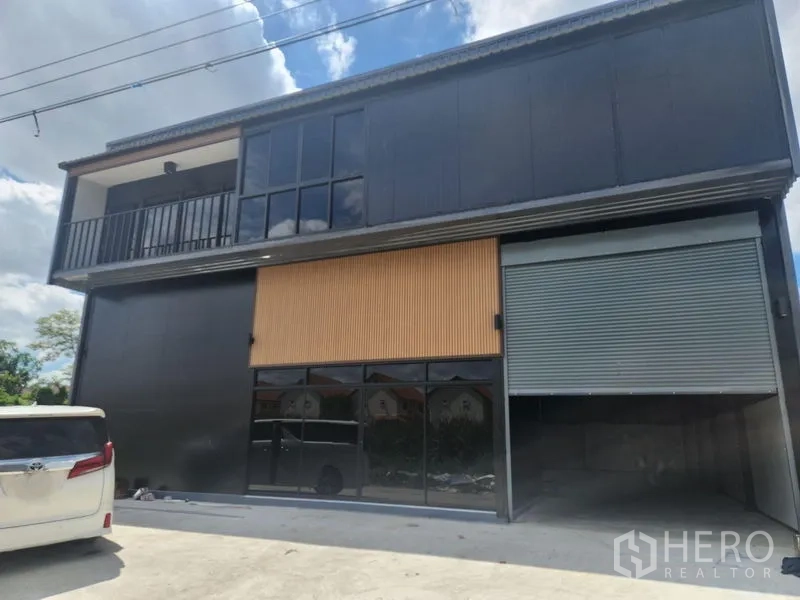 คลังสินค้า ให้เช่าหรือขายในLam Luk Ka, Pathum Thani - มุมมองภายนอกของโกดัง โชว์หน้ากระจก ระเบียง และทางเข้าประตูม้วนขนาดกว้าง