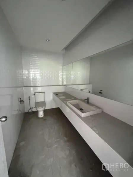 店屋 出租在Watthana, Bangkok - 整洁卫生间，长台面、洗手盆、大镜子与坐便器。