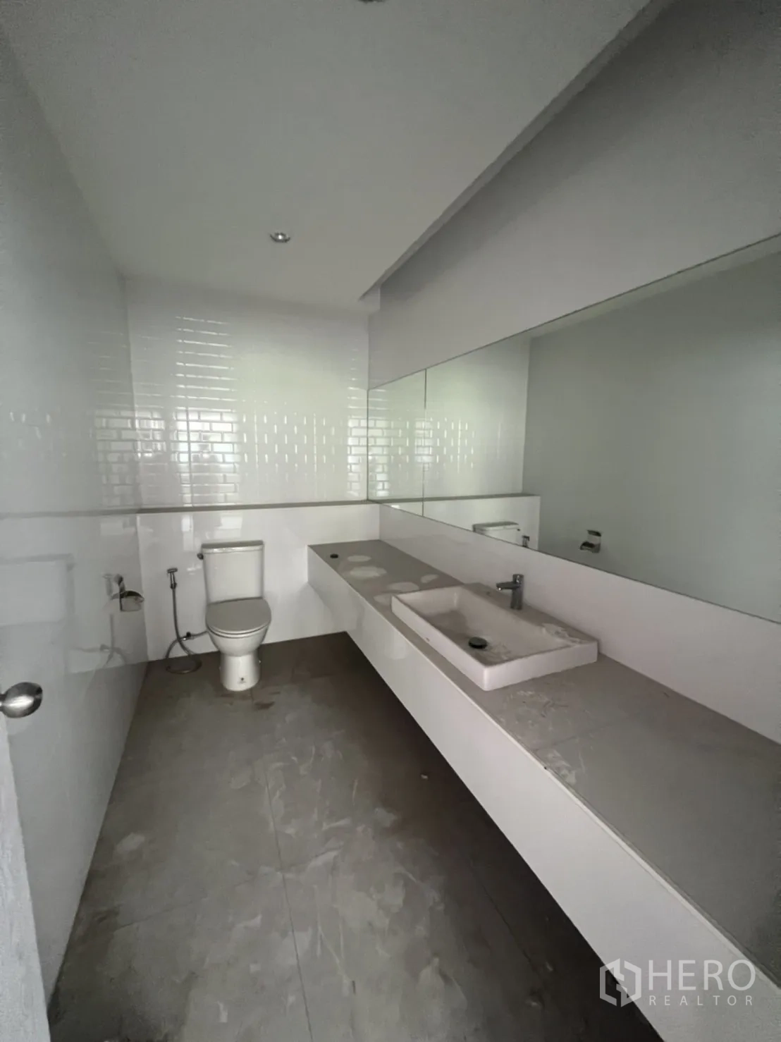 店屋 出租在Watthana, Bangkok - 整洁卫生间，长台面、洗手盆、大镜子与坐便器。