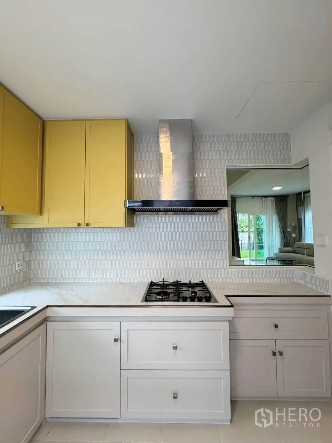 Detached House for rent in Bang Phli, Samut Prakan - Kitchen view showing gas hob, range hood, and a serving window.
