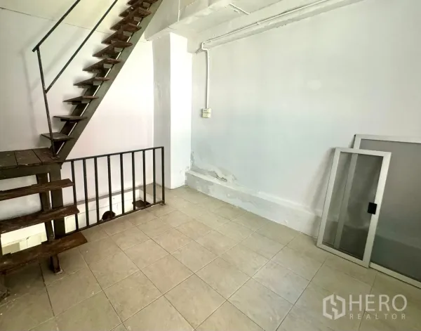 零售空间 出租在Watthana, Bangkok - 开放式空间，带工业风金属楼梯与瓷砖地面。