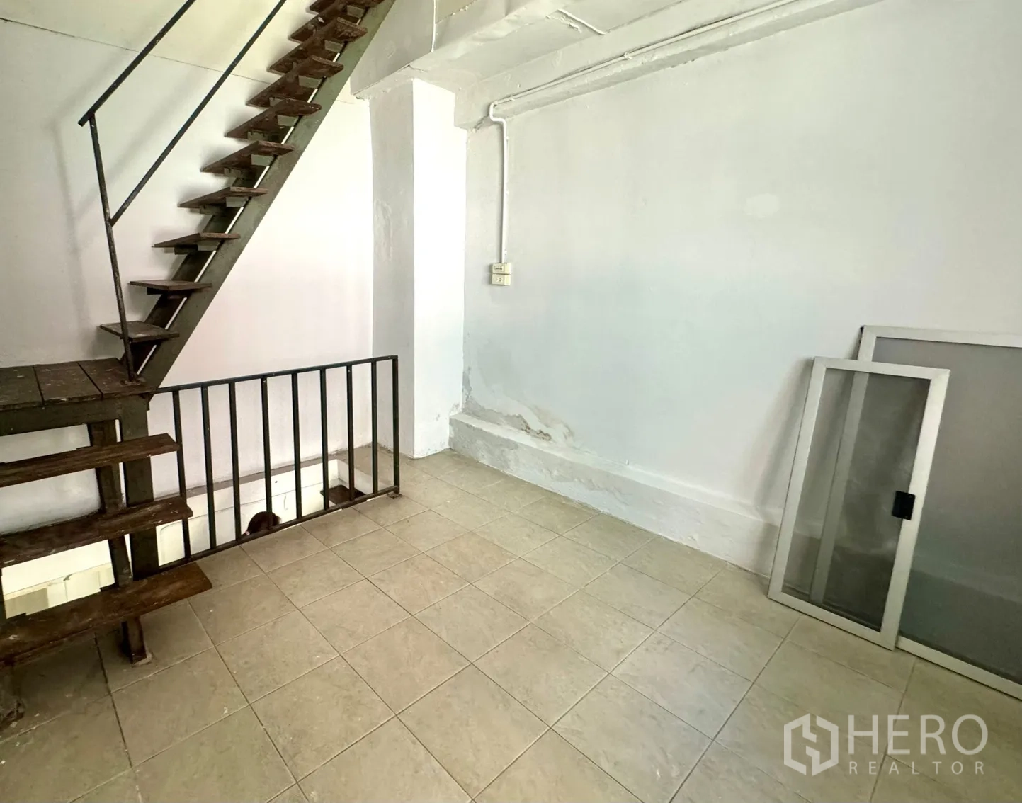 零售空间 出租在Watthana, Bangkok - 开放式空间，带工业风金属楼梯与瓷砖地面。