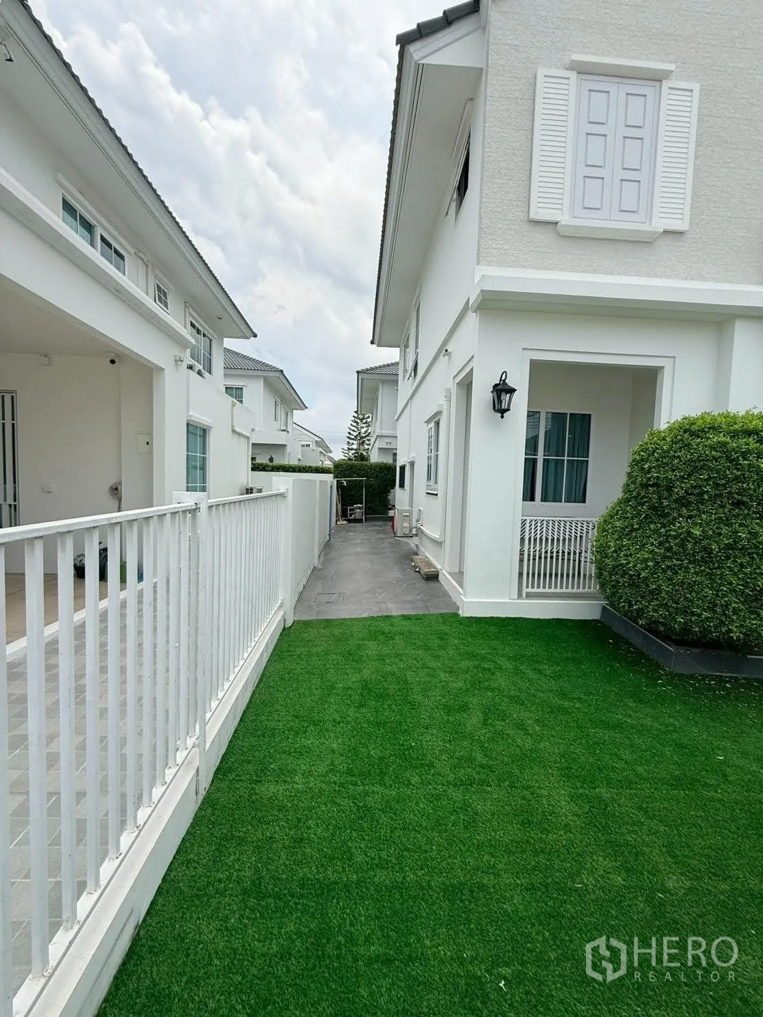 Detached House for rent in Bang Phli, Samut Prakan - Narrow lawn strip and white fence between neighboring houses.