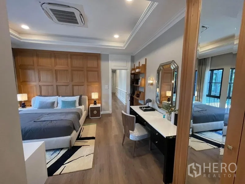 บ้าน ให้เช่าหรือขายในSaphan Sung, Bangkok - ห้องนอนมาสเตอร์กว้าง ผนังไม้กรุ แท่นเขียนหนังสือ และชั้นวางบิลท์อิน