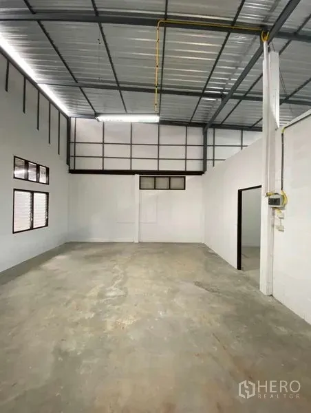 货栈 出租在Bang Khen, Bangkok - 仓库主厅，挑高天花，百叶窗，日光灯与混凝土地面