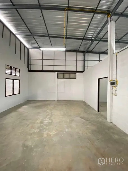 货栈 出租在Bang Khen, Bangkok - 仓库主厅，挑高天花，百叶窗，日光灯与混凝土地面