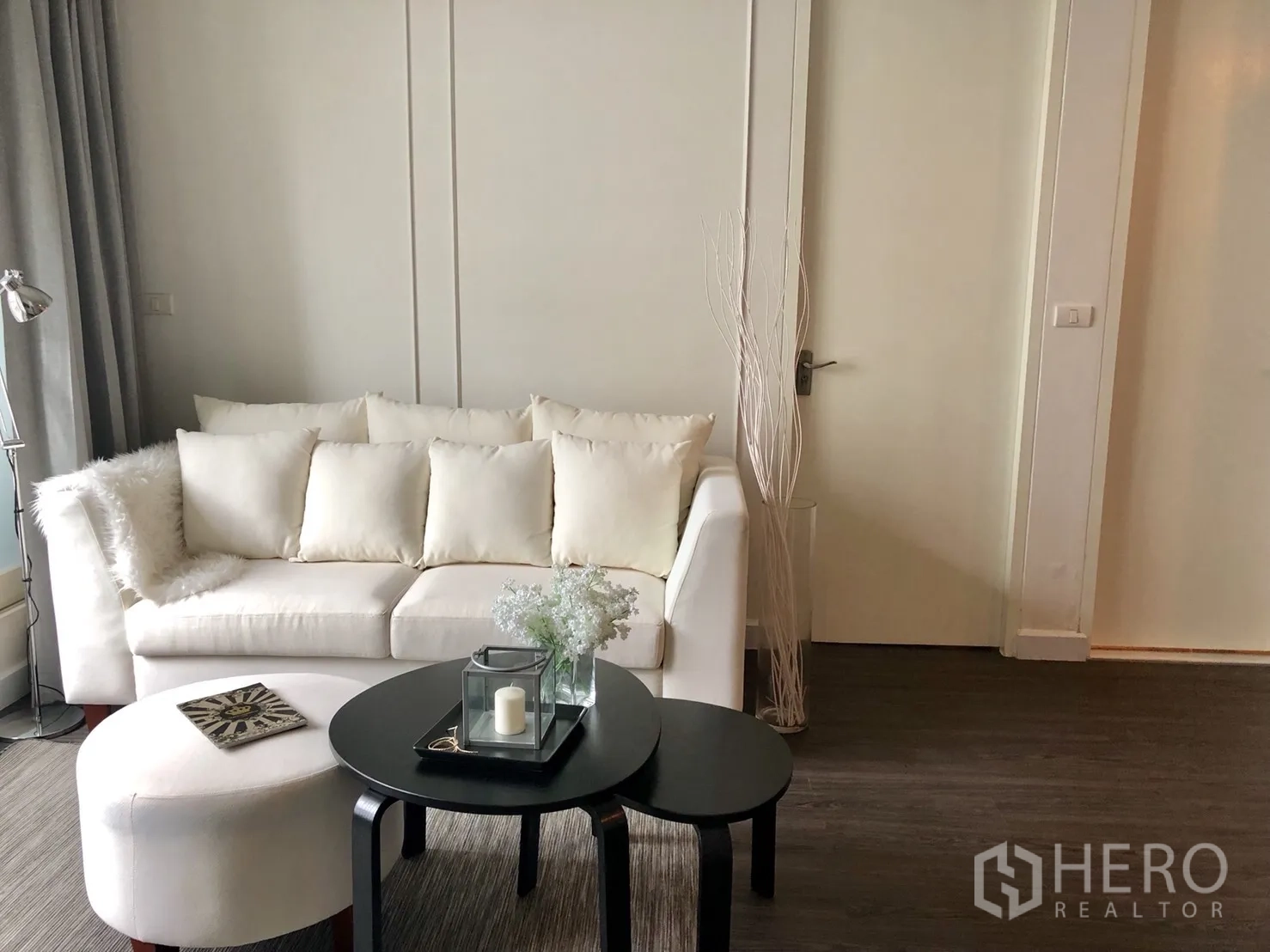 คอนโด ให้เช่าในPathum Wan, Bangkok - ห้องนั่งเล่นอบอุ่น โซฟาสีครีม โต๊ะกลางซ้อน และพื้นไม้