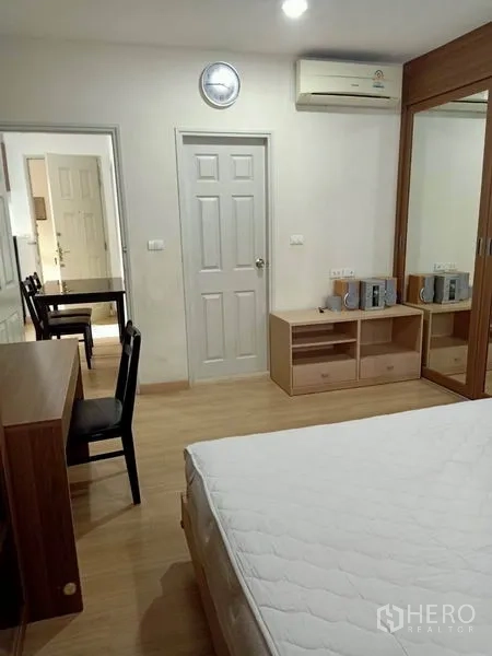 Condominium for rent in Bang Rak, Bangkok - Master bedroom view toward doorway with desk, storage cabinet and air conditioner.