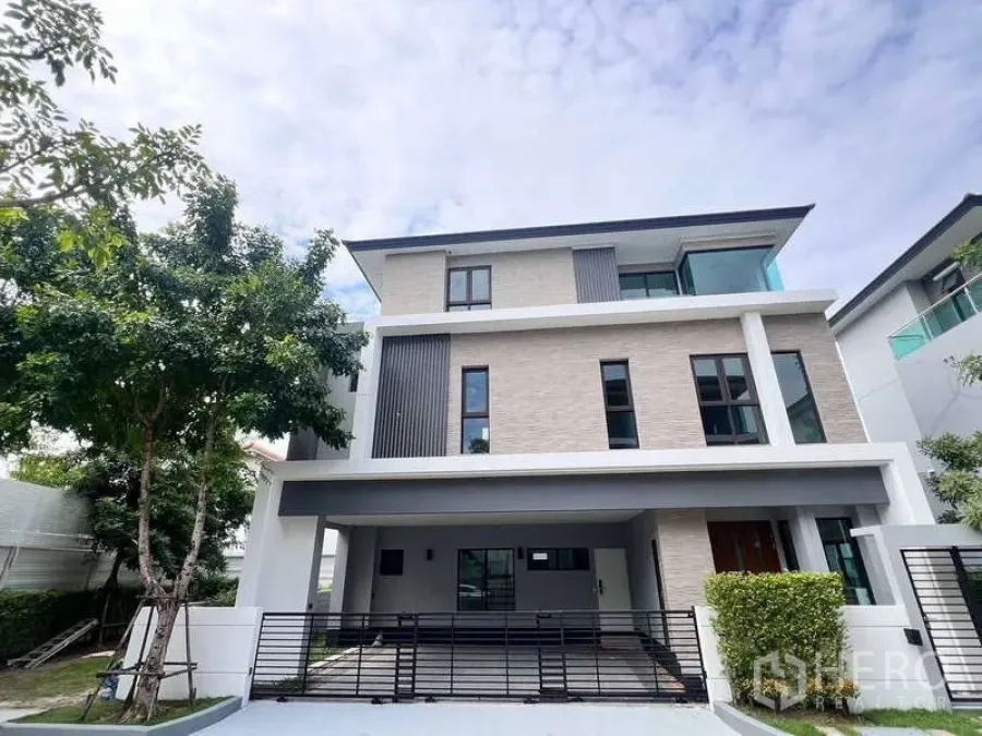Detached House for rent in Wang Thonglang, Bangkok - Front elevation of the three-storey detached house with sliding gate and covered parking.